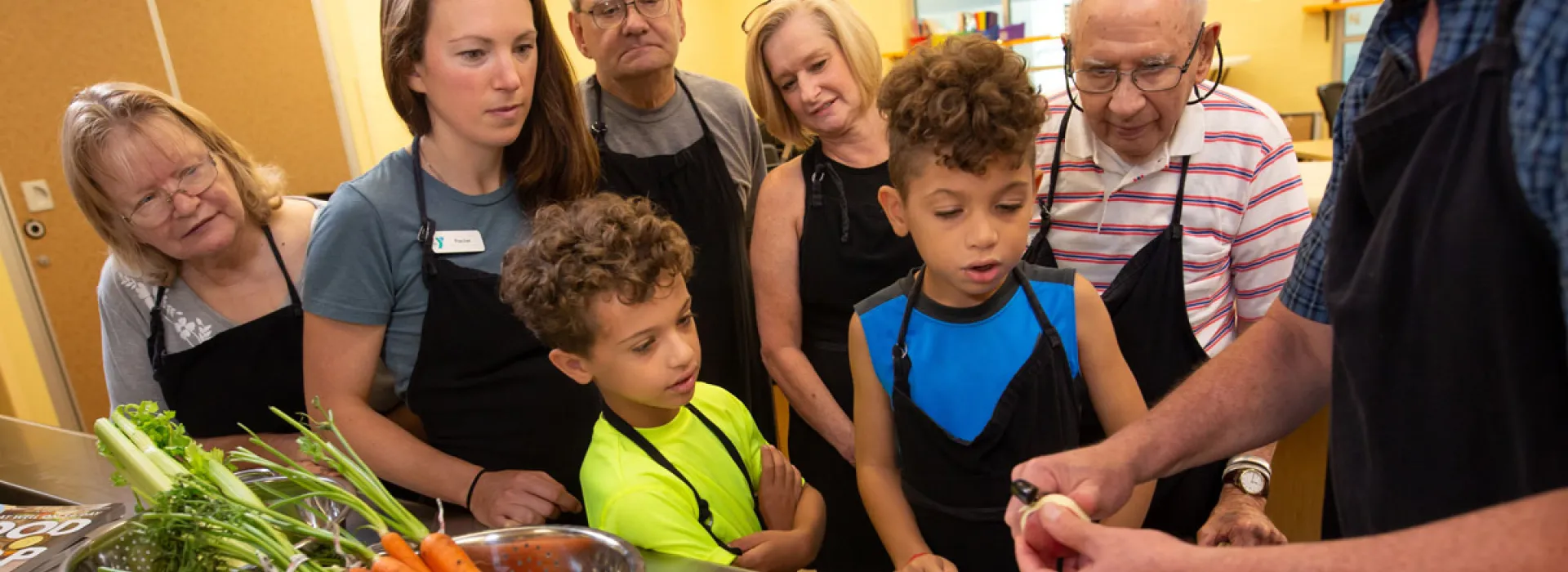 y members learning to cook in the teaching kitchen