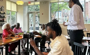 August Wilson House board President Ervin Dyer prepares participants gathered last year for an Everyday Cafe story circle. 